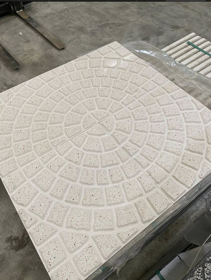 Dalle granit claire à motif rosace présentée en atelier à Menars